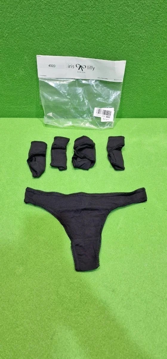 Conjunto de ropa interior negra en fondo verde.