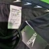 Etiqueta de bañador Speedo negro sobre fondo verde.
