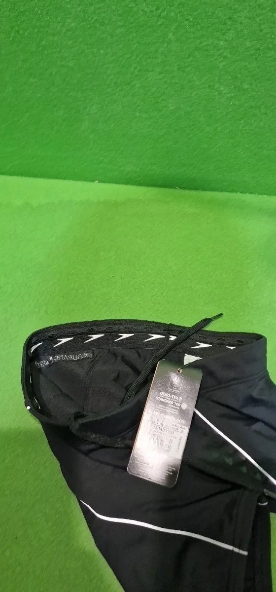 Pantalón negro con etiqueta y fondo verde